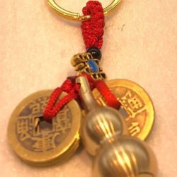 A key chain with two chinese coins and beads.