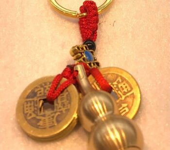 A key chain with two chinese coins and beads.