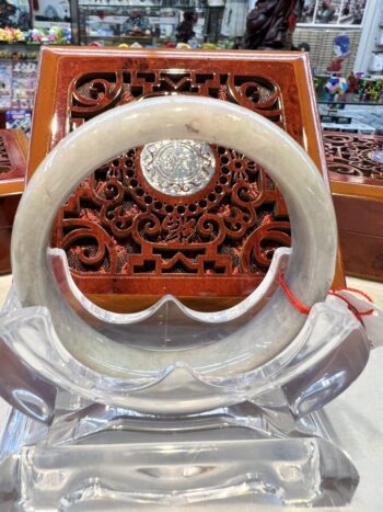 A white and red circular stone display in front of an ornate wooden carving.