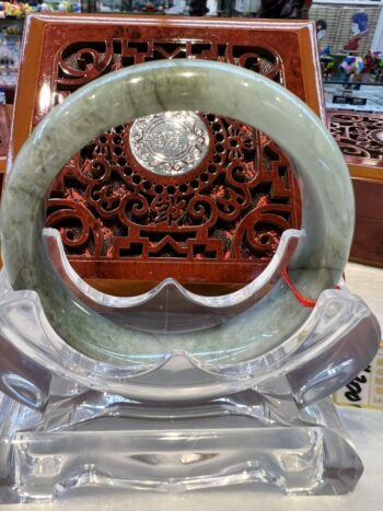 A large green jade ring sitting on top of a table.