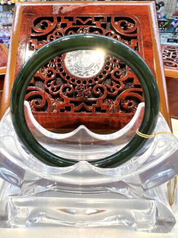 A green bangle sitting on top of a clear plastic chair.