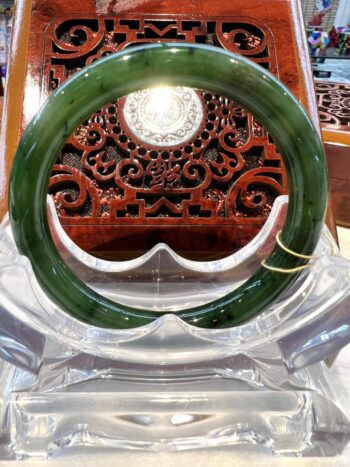 A green jade bangle sitting on top of a table.