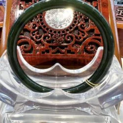 A green bangle sitting on top of a clear plastic container.