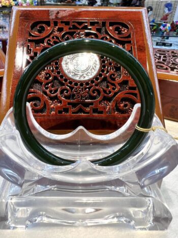 A green and white ring sitting on top of a wooden chair.