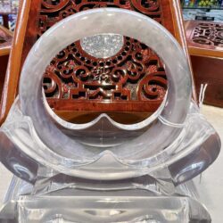 A clear plastic chair with an intricate wooden design.