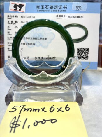 A green bangle sitting on top of a glass display.