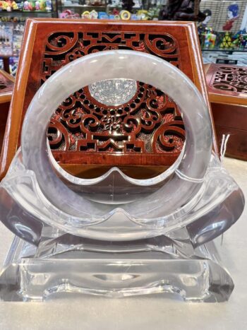 A clear plastic chair with an intricate wooden design.