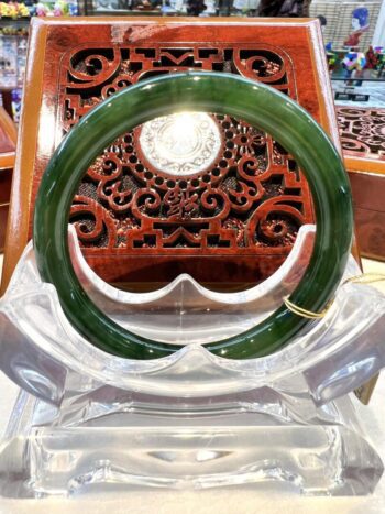 A green and clear bangle sitting on top of a wooden chair.