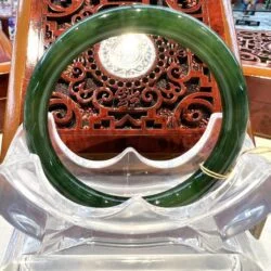 A green and clear bangle sitting on top of a wooden chair.