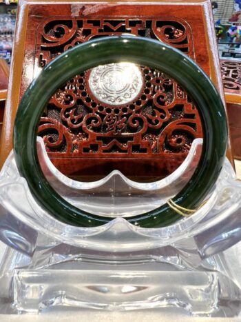 A green glass ring sitting on top of a clear plastic chair.