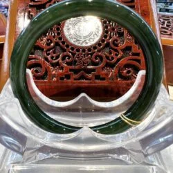 A green glass ring sitting on top of a clear plastic chair.