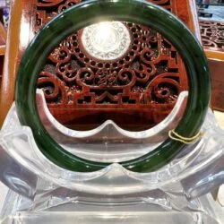 A green glass ring sitting on top of a clear chair.