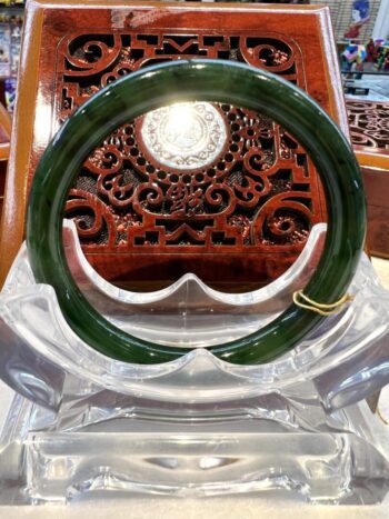 A green glass ring sitting on top of a clear chair.