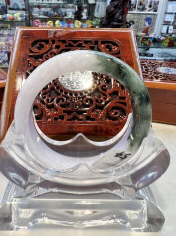 A large circular glass sculpture with a wooden carving.