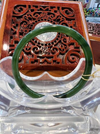 A green bangle sitting on top of a wooden table.