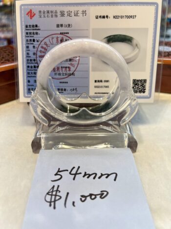 A white and green jade bangle is displayed.