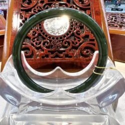 A green bangle sitting on top of a clear chair.