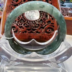 A large green jade bangle sitting on top of a table.