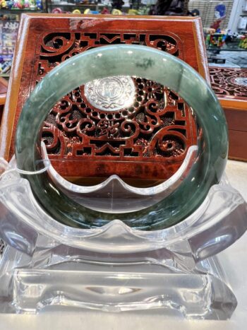 A large green jade bangle sitting on top of a table.