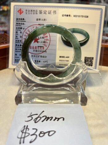 A green jade bracelet sitting on top of a table.