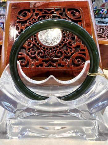 A green plastic bangle sitting on top of a clear chair.