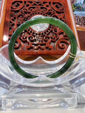 A green bangle sitting on top of a wooden table.