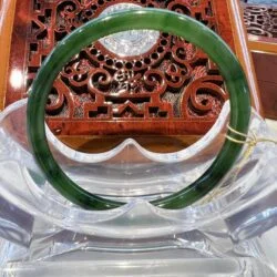 A green bangle sitting on top of a wooden table.