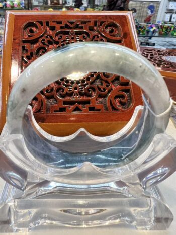 A clear plastic bracelet sitting on top of a wooden chair.