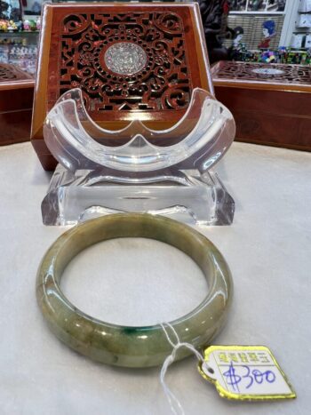 A green stone bracelet sitting on top of a table.