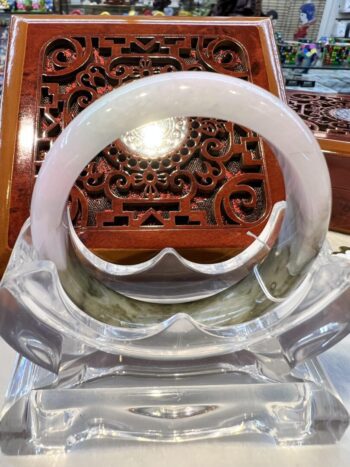 A white bangle sitting on top of a clear glass bowl.