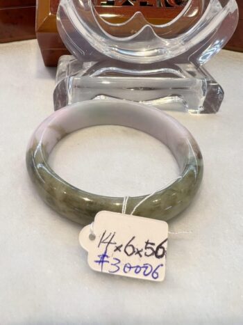 A green and white bangle sitting on top of a table.