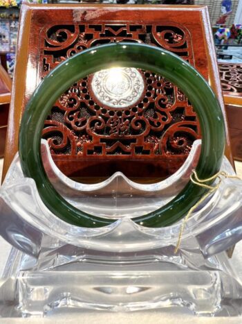 A green and white ring sitting on top of a wooden table.