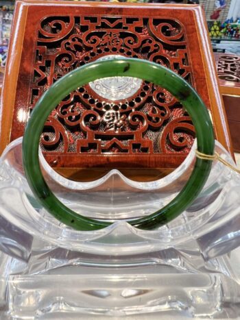 A green jade bangle sitting on top of a table.