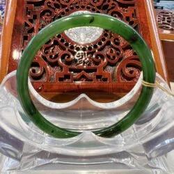 A green jade bangle sitting on top of a table.