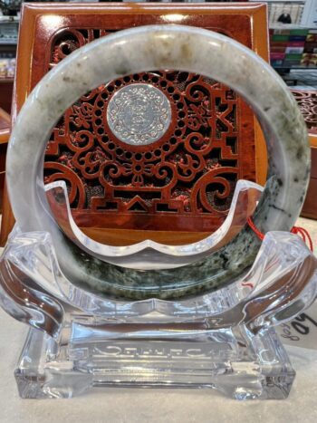 A large round stone bracelet sitting on top of a glass display.