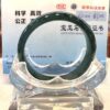 A green bracelet sitting on top of a clear stand.