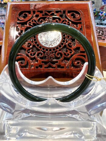 A green plastic bangle sitting on top of a wooden chair.