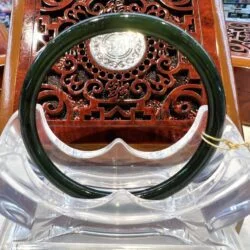 A green plastic bangle sitting on top of a wooden chair.