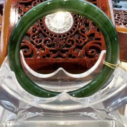 A green glass ring sitting on top of a clear chair.