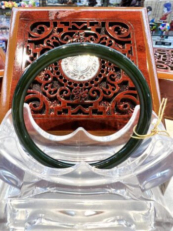 A green plastic ring sitting on top of a wooden chair.