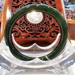 A green bangle sitting on top of a wooden chair.