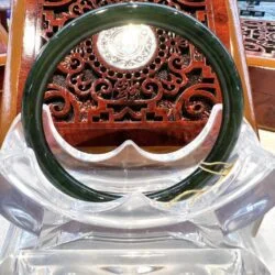 A green and white ring sitting on top of a wooden chair.