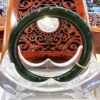 A green bangle sitting on top of a wooden chair.