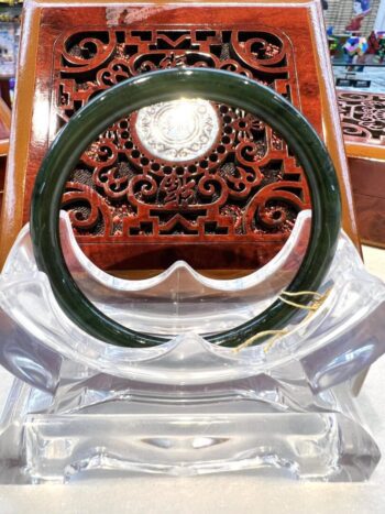 A green and white ring sitting on top of a wooden chair.