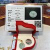 A green jade pendant in an open red box.