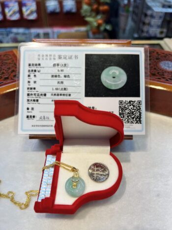 A green jade pendant in an open red box.