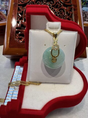 A white purse with a green stone on it