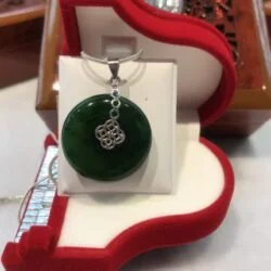 A green pendant sitting in a red box.