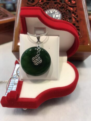 A green pendant sitting in a red box.