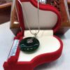 A green glass pendant sitting on top of a red box.